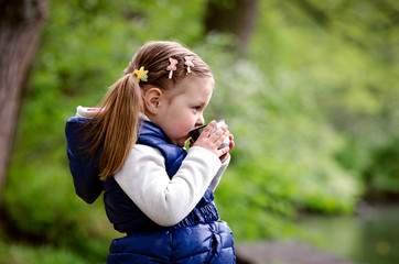Little girl drinking tea outdoors
