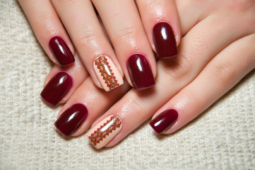 burgundy manicure with Ukrainian ornament on the ring finger