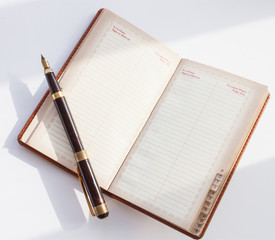 notepad with pen on a white table