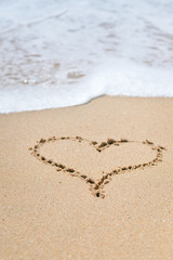 Top view of love heart drawn on sand. Background composition.