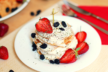 studio photo of breakfast table, sweet pancakes with summer berries  