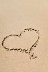 Top view of love heart drawn on sand. Background composition.