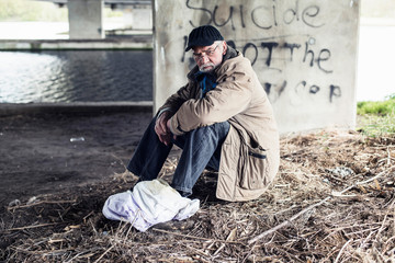 Wanderer sitting under bridge.