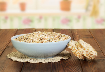 Bowl of oatmeal and crispbread on  background dark wood.