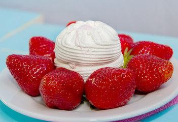 Ripe fresh strawberries and zephyr marshmallow cake on a white plate, closeup