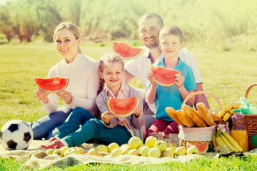 Family eating watermelon on the picnic.