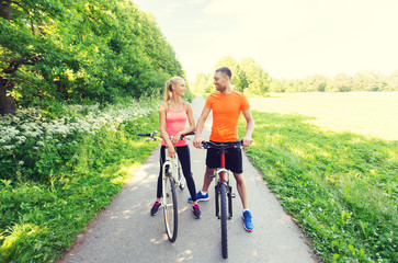 happy couple riding bicycle outdoors