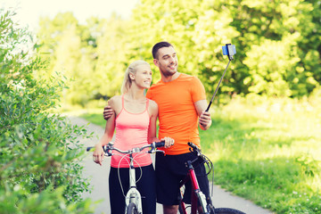 couple with bicycle and smartphone selfie stick