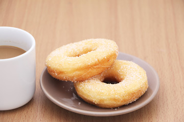 yeast donut with sugar and coffee on wooden background