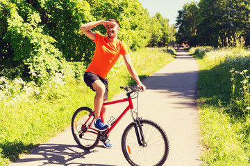 happy young man riding bicycle outdoors