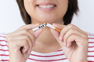 concept : "World no tobacco day" Woman are breaking tobacco with the word baby. Mom decided to quit smoking to child.