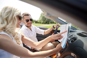 happy man and woman with map in cabriolet car