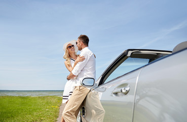 happy couple hugging near cabriolet car at sea