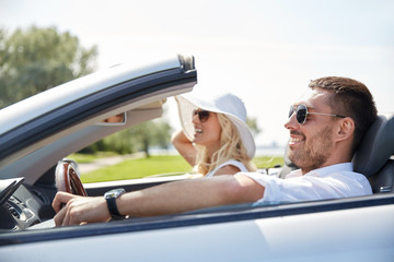 happy man and woman driving in cabriolet car