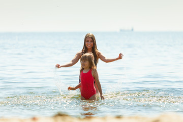Fototapeta na wymiar Little girl kid and woman mother in sea water. Fun