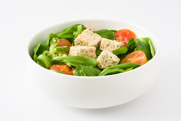 Vegan tofu salad with tomatoes and lamb's lettuce isolated on white background
