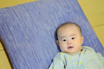 座布団に寝転ぶ赤ちゃん