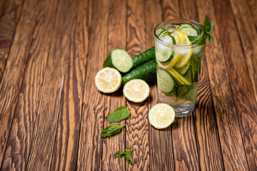 Water with lemon, mint and cucumber on wooden background. Water Detox.