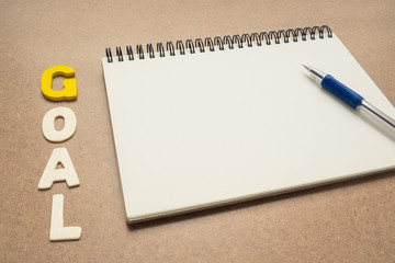 GOAL wording with open spiral notebook and pen