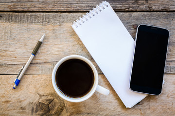 cup of coffee and smartphone with paper note on wood table backg