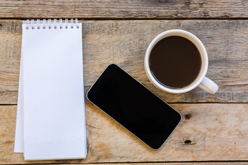 cup of coffee and smartphone with paper note on wood table backg