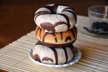 Donuts with chocolate on a brown plate on the table