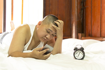 Monday morning Asian man lying on the bed. Lazy Man concept