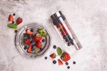 Infused water in glass bottle and fresh berries