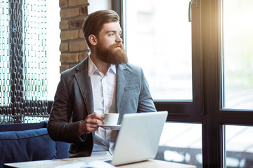 Fototapeta premium Pleasant bearded man drinking coffee 