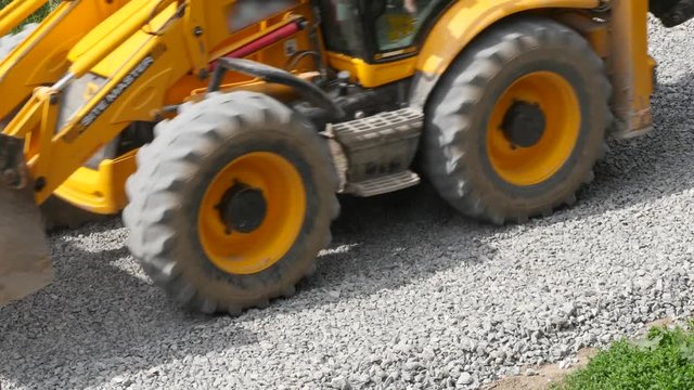 Excavator carries gravel in the bucket on road construction