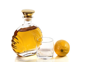 Bottle whiskey and empty tumbler with lemon on white background