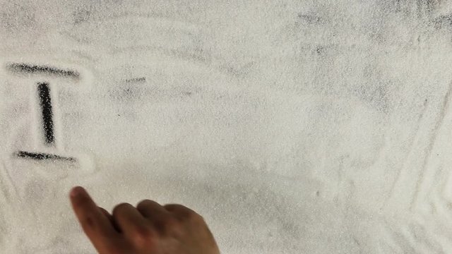 Men hand draws word I love yuo on the surface of sugar