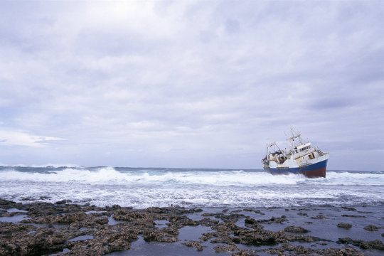 Ship run aground in the water`s edge.