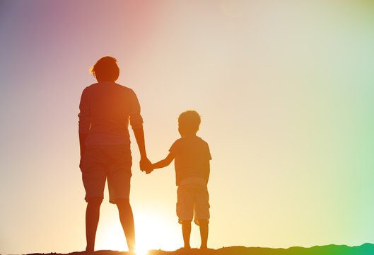 Silhouette Of Father And Son Holding Hands At Sunset