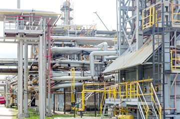 Industrial equipment and pipelines at the gas processing plant on a summer day