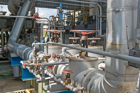 Industrial equipment and pipelines at the gas processing plant on a summer day