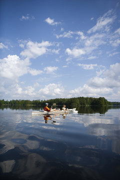 Father and son in canoe paddling across lake, Immeln, Skane, Sweden.