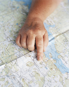 A hand pointing on a map, Sweden.