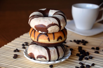 Traditional  donuts  with brown chocolate on the plate on the table