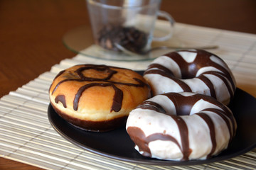 Traditional  donuts  with brown chocolate on the plate on the table