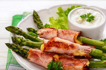 Green asparagus grilled with ham and cheese, served with garlic sauce.