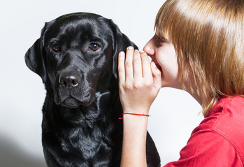 Young boy hugging black labrador
