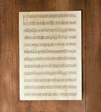 Aged sheet music, shot from above on wooden texture