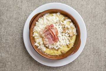 banosh with cheese and bacon in a clay bowl