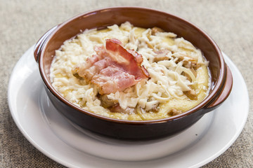 banosh with cheese and bacon in a clay bowl