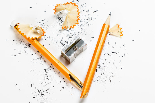 Broken pencil with metal sharpener and shavings.