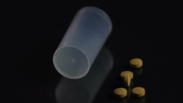 Pill bottle falling on black surface, patient dropping ineffective medicine