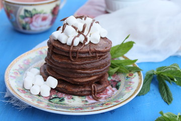 Chocolate pancakes with marshmallows at breakfast