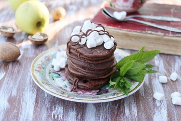 Chocolate pancakes with marshmallows at breakfast