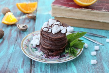 Chocolate pancakes with marshmallows at breakfast
